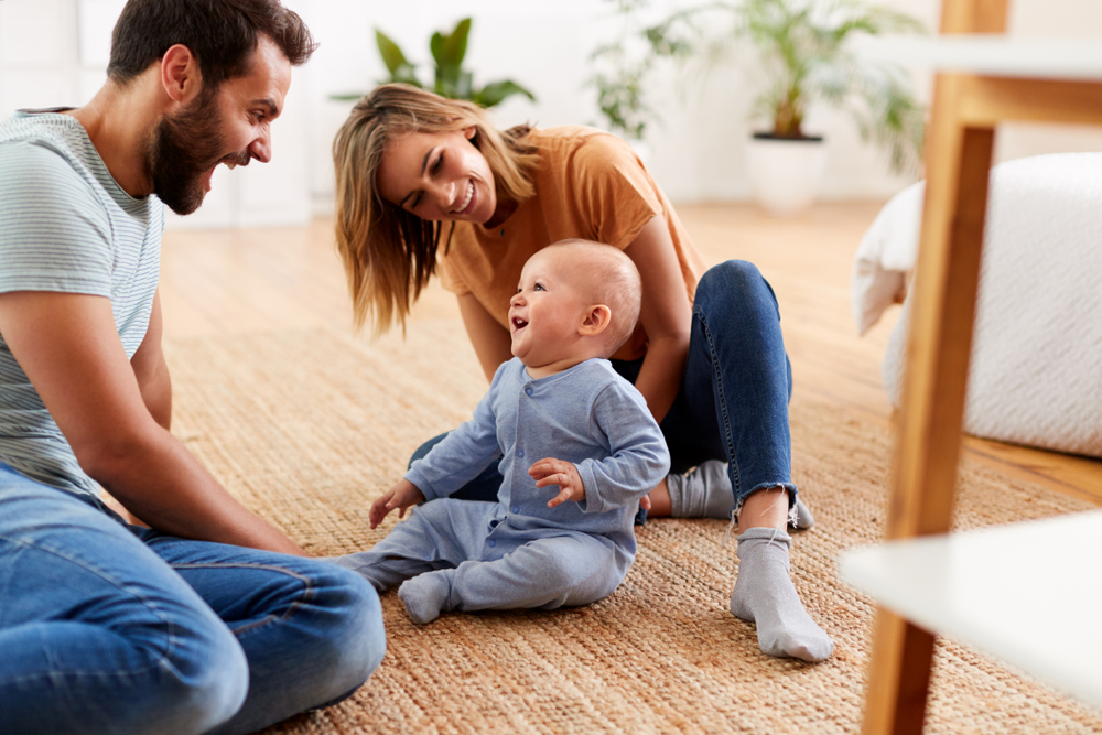 Parents,Sitting,On,Floor,At,Home,Playing,With,Baby,Son